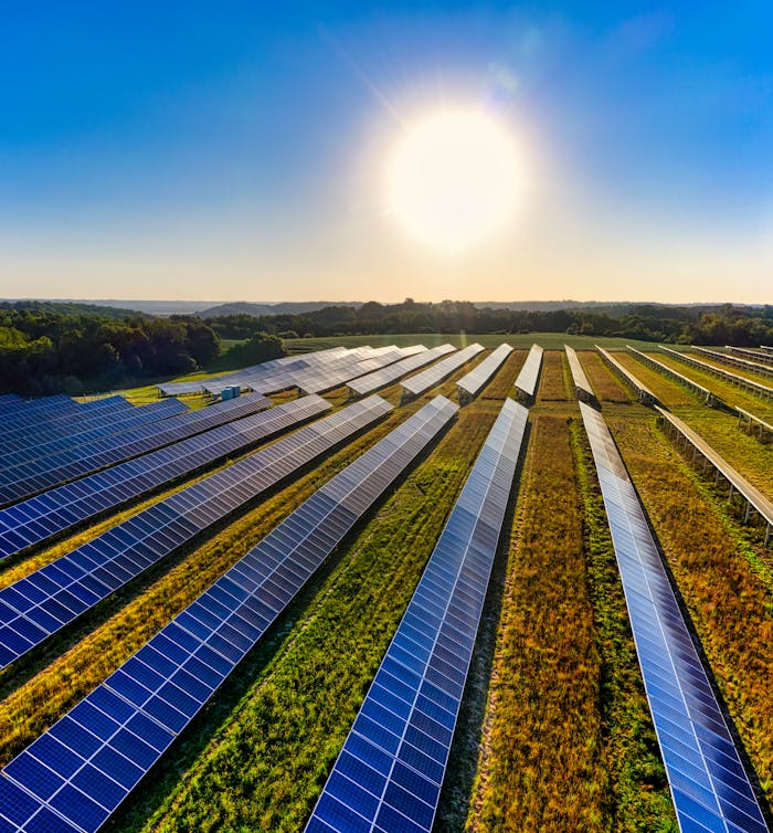 Aerial view of a solar farm managed by 3K Services, featuring solar panels under bright sunlight